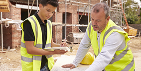 Young man working and taking notes with adult